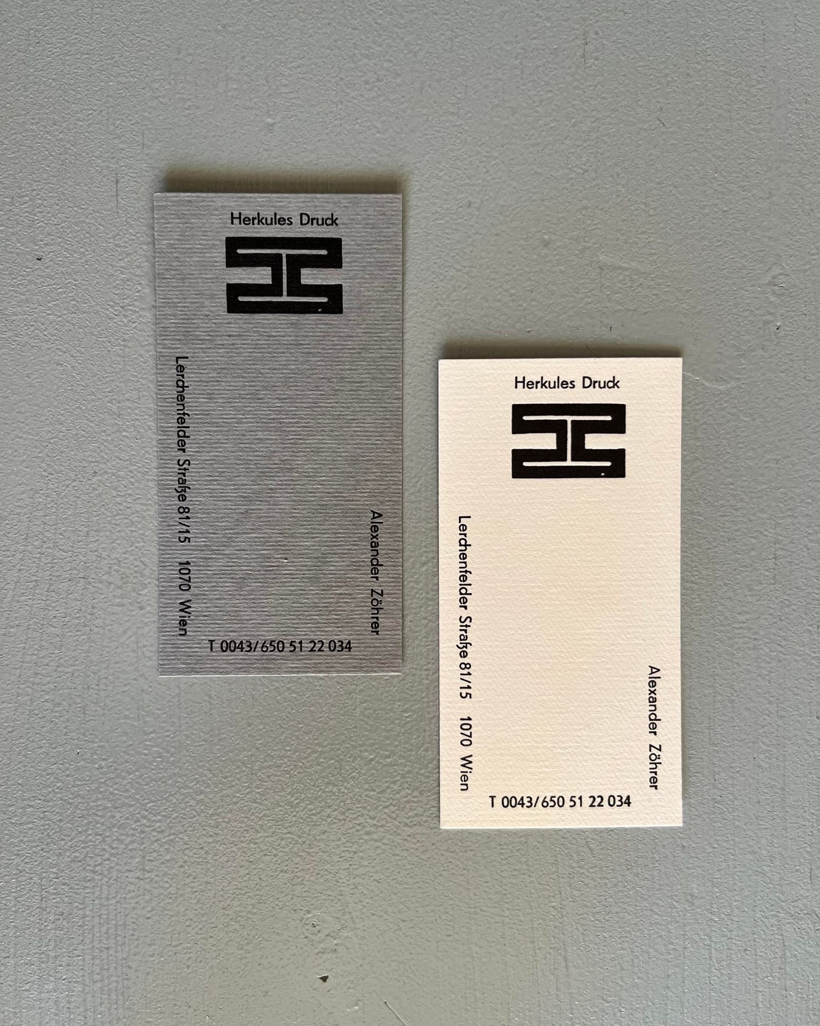 Zwei Visitenkarten von Herkules Druck mit dem H-Logo